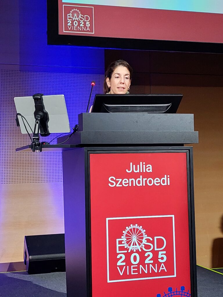 Professor Julia Szendroedi from Heidelberg (Germany) stands behind the lectern on the stage and gives her presentation.